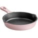 A pink enameled cast iron skillet with a black handle.