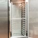 An unassembled aluminum sheet pan rack in a stainless steel reach-in refrigerator.