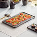 An Acopa black matte rectangular stoneware plate with sushi on it.