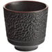 A black Acopa stoneware tea cup with a textured surface.