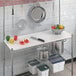 A kitchen with a Regency wire shelf and utensils stored in a Regency Polyethylene cutting board insert.