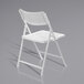 A National Public Seating white plastic folding chair with a metal frame.