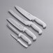 A group of Choice Essential knives with white handles on a gray surface.