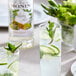 A glass of Monin Mojito mix with ice and lime slices.