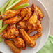 A plate of Lawry's Sriracha wing seasoning on chicken wings with celery and carrots.