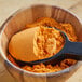 A bowl filled with Lawry's Spicy Buffalo Wing Seasoning Mix powder with a scoop.