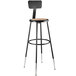 A black metal lab stool with a round hardboard seat.