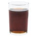 A Libbey straight sided glass filled with brown liquid on a white background.