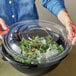 A woman holding a Visions clear plastic dome lid over a bowl of food.