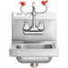 A white rectangular stainless steel wall mounted hand sink with two faucets and red eyewash handles.