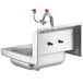 A Regency stainless steel wall mounted hand sink with two pipes and red knobs.