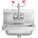 A stainless steel Regency wall mounted hand sink with faucets and a eyewash station.