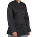 A woman wearing a black Uncommon Chef long sleeve chef coat with side vents.