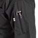 A close up of the pocket on a black Uncommon Chef Aruba Pro Vent chef coat with mesh back.