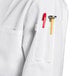 A close up of a white Uncommon Chef long sleeve chef coat pocket.