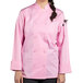 A woman wearing a Uncommon Chef pink long sleeve chef coat with a mesh back.