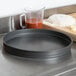 An American Metalcraft hard coat anodized aluminum round cake pan on a counter.