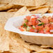 A Fineline Flairware ivory plastic oval bowl filled with salsa on a table with tortilla chips.
