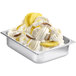 A bowl of white ice cream with pineapple slices and yellow and white ice cream in a white bowl.