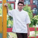 A man wearing a Uncommon Chef white chef coat with mesh venting.