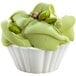 A white bowl of green Fabbri Fabbrisoff ice cream with nuts on top.