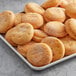 A tray of Rich's unfilled round donut shells on a gray surface.