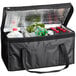 An American Metalcraft black polyester insulated delivery bag with food and drinks inside.