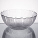 An Arcoroc clear glass bowl with a flower design.