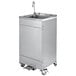 A stainless steel T&S portable handwashing station with wheels.