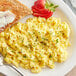 A white plate with scrambled JUST Egg and strawberries.