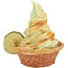 Soft serve lime ice cream in a waffle bowl with a lime wedge on top.