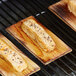 Rectangular pieces of salmon on a Backyard Pro cedar wood grilling plank on a grill.