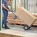 A man pushing a Lavex hand truck with a large box.