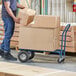 A man using a Lavex convertible hand truck to move boxes.