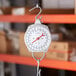 An AvaWeigh industrial hanging scale hanging from a hook.