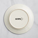An ivory stoneware plate with the word Acopa embossed on the rim.