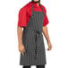 A man wearing a black and white striped Uncommon Chef butcher apron.