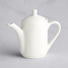 A Tuxton eggshell white teapot with a lid.