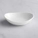 A Tuxton porcelain white oval china bowl on a white surface.