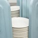 A stack of white plates in a blue Metro dish dolly.