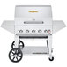 A Crown Verity stainless steel outdoor mobile grill with wheels and knobs.