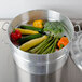 A Town aluminum steamer pot filled with vegetables on a stove.