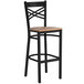 A Lancaster Table & Seating black metal bar stool with a wood seat.