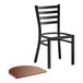 A black Lancaster Table & Seating ladder back chair with a vintage wood seat.