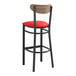 A black Lancaster Table & Seating bar stool with red vinyl seat and vintage wood back.