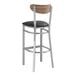 A Lancaster Table & Seating Boomerang bar stool with a black vinyl seat.