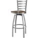 A Lancaster Table & Seating swivel bar stool with a wooden seat and metal frame.