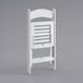 A white Lancaster Table & Seating folding chair with a slatted seat on a grey background.