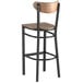 A Lancaster Table & Seating black bar stool with vintage wood seat and backrest.