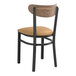 A Lancaster Table & Seating Boomerang Series black chair with light brown vinyl seat.